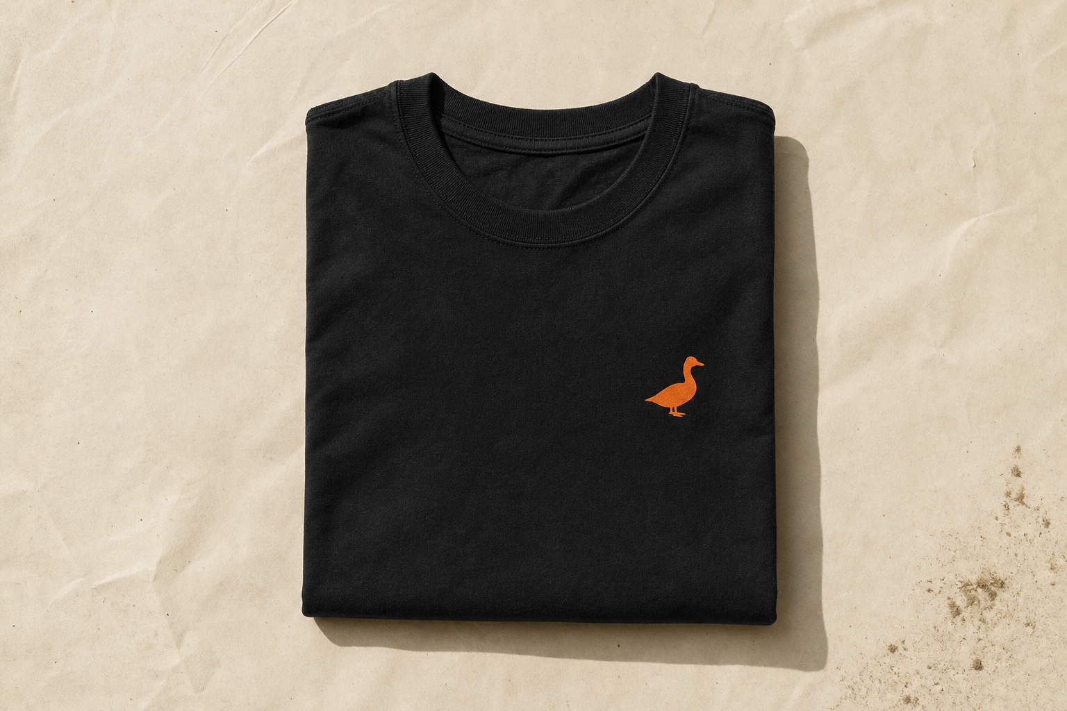 Black tee with a small orange duck on the chest